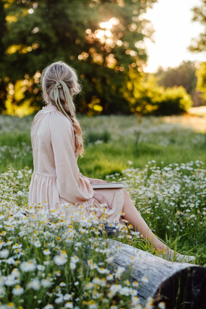 Woman reflecting in a field during late spring while creating space for what matters.