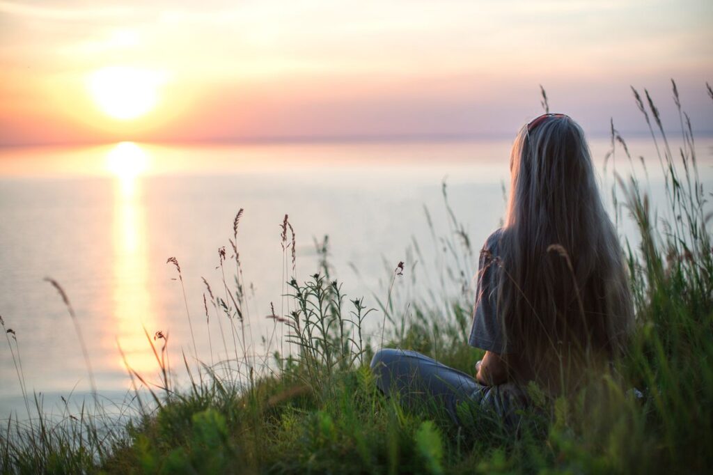 Woman enjoying a quiet summer morning with tea while creating a daily rhythm to support energy and well-being.