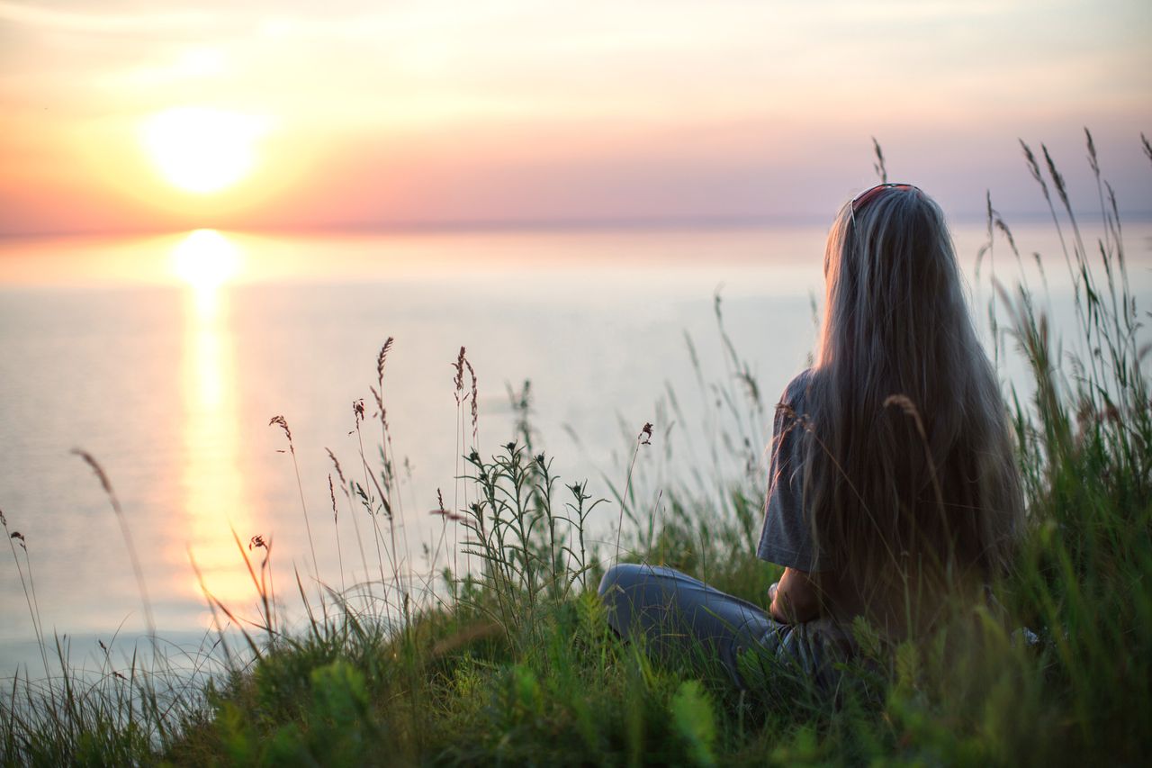 Woman enjoying a quiet summer morning with tea while creating a daily rhythm to support energy and well-being.